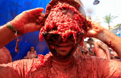 Un hombre se retira las gafas de sol, cubiertas de tomate, durante la fiesta popular de la Tomatina, en Buñol, este miércoles.