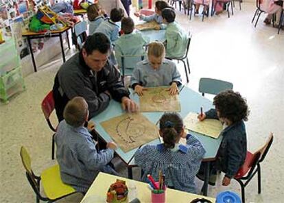 Un maestro imparte una clase a niños de educación infantil en un colegio de Sevilla.