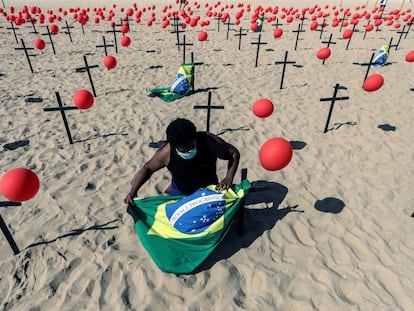 Ativista posiciona bandeira do Brasil em protesto da ONG Rio de Paz pelas vítimas do coronavírus, no Rio de Janeiro, no domingo.