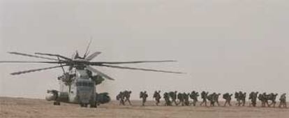 Soldados del Primer Batallón de Marines, con base en Camp Pendleton (California), bajan de un helicóptero Super Stallion en el desierto de Kuwait.