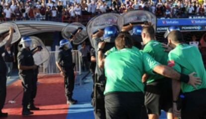 El cuarteto arbitral se dirige al túnel de vestuarios escoltado por la policía en el partido San Lorenzo, 1 - Colón de Santa Fé, 1