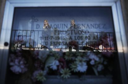 Dos mujeres reflejadas en un nicho del cementerio de La Almudena (Madrid).