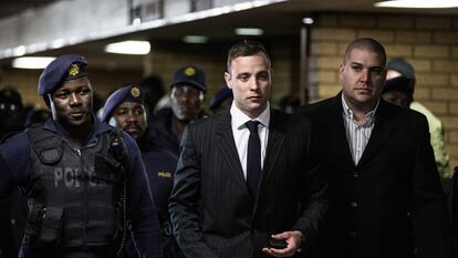 South African Paralympian Oscar Pistorius (C) is surrounded by policemen as he arrives at Pretoria High Court to attend a sentencing hearing set to send him back to jail for murdering his girlfriend Reeva Steenkamp three years ago, in Pretoria on June 13, 2016.