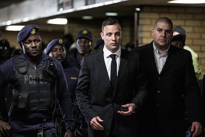 South African Paralympian Oscar Pistorius (C) is surrounded by policemen as he arrives at Pretoria High Court to attend a sentencing hearing set to send him back to jail for murdering his girlfriend Reeva Steenkamp three years ago, in Pretoria on June 13, 2016.