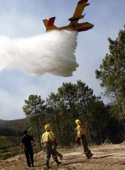 Miembros de un retén miran la descarga de un avión.