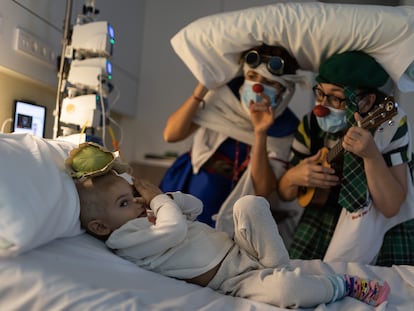 Luis Escuder, de dos años y medio, juega con unas payasas de la ONG Pallapupas en su habitación del Sant Joan de Déu Pediatric Cancer Center.