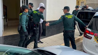 Agentes de la Guardia Civil trasladan a uno de los dos detenidos por el asesinato de una vecina de 65 años del municipio valenciano de Rafelcofer, profesora jubilada.