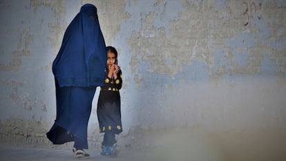 Una mujer afgana con burka caminaba ayer con una niña por una calle de Kabul.