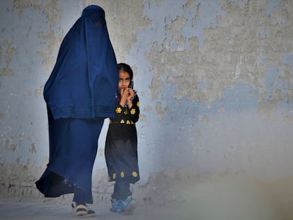 Una mujer afgana con burka caminaba ayer con una niña por una calle de Kabul.