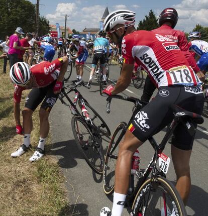 Tomasz Marczynski (I) y Jelle Vanendert intentan volver a la carretera después de una caída.