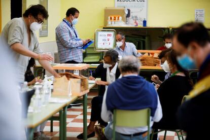 Apoderados de los distintos partidos controlan el recuento y voto por correo, en el Colegio Ciudad de Roma de Madrid.