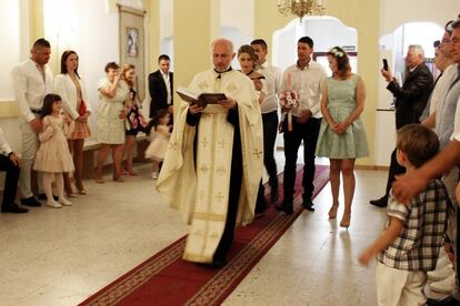 Tras el ritual inicial, el párroco entra en la iglesia seguido de los padrinos, con la niña en brazos, y los padres de Carla. En el interior esperan los invitados a la ceremonia.