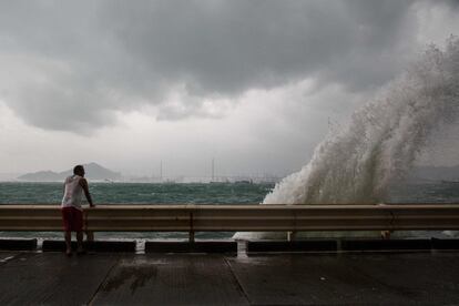 Un hombre observa como una ola provocada por los vientos del tifón Haima choca contra la costa de Hong Kong.