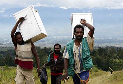 Funcionarios electorales transportan urnas en un remoto pueblo de Papúa.
