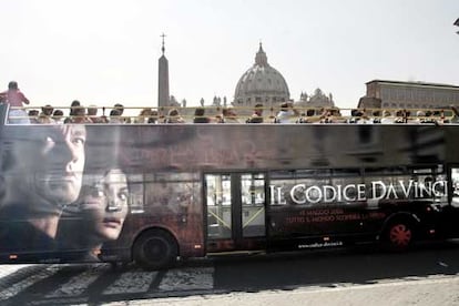 El anuncio de <i>El código Da Vinci</i> en un autobús <i>enmarca,</i> el viernes, la cúpula de San Pedro, en el Vaticano.