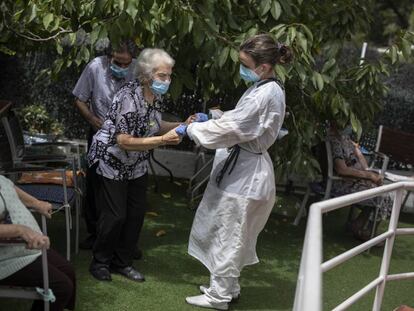 Una cuidadora atén una dona gran a la residència geriàtrica Gravi, a Polinyà.