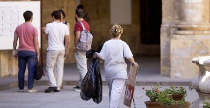 Una limpiadora recoge basura en el rectorado de la Universidad de Sevilla.