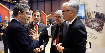 El ministro Álvaro Nadal conversa con el director general de Turismo de la Generalitat, Octavi Bono, en Fitur.