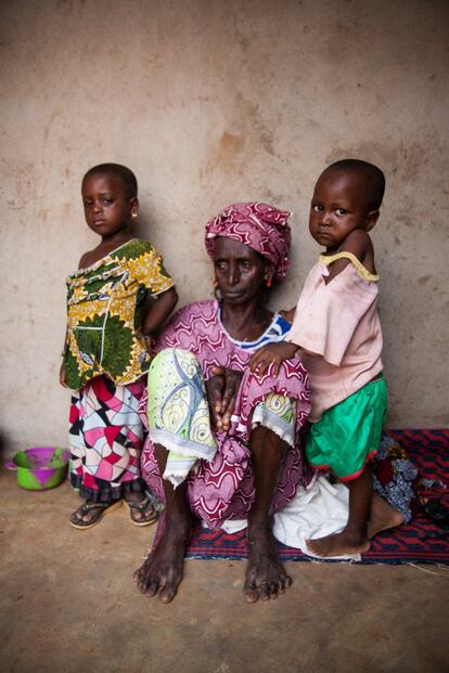 Fatoumata Barry, de 85 años, junto a dos de sus nietos en el cuarto de aperos donde vive a las afueras de Bamako.