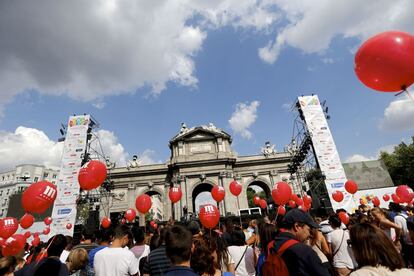 Numerosas personas siquen desde una pantalla instalada en la Puerta de Alcalá la presentación de la candidatura de Madrid.