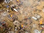 In this aerial picture taken on April 26, 2021, relatives and friends of a victim who died of the Covid-19 coronavirus gather to cremate the body at a cremation ground in New Delhi. (Photo by Jewel SAMAD / AFP)