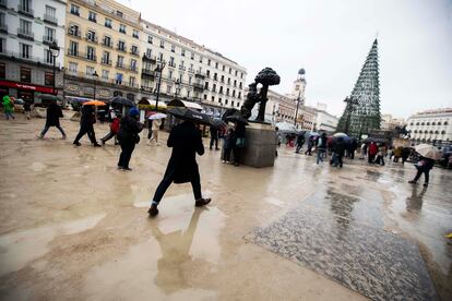 La Puerta del Sol llena de paseantes, pese a la lluvia, este lunes. 