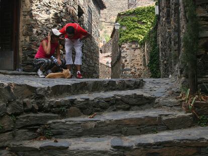 Unos niños juegan con un gato en Patones de Arriba.