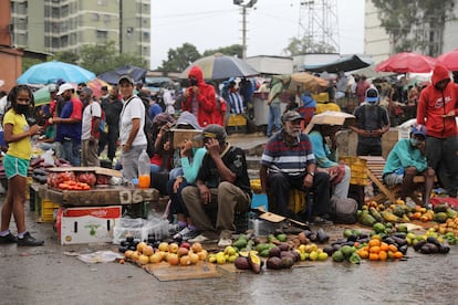 Vendedores trabajan bajo la lluvia en el mercado de Coche de Caracas. 