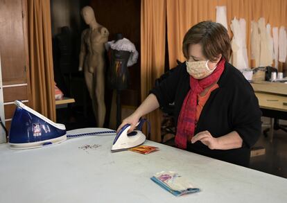 Una empleada plancha una mascarilla en los talleres de vestuario del Teatro Nacional Cervantes, en Buenos Aires, el 15 de abril.