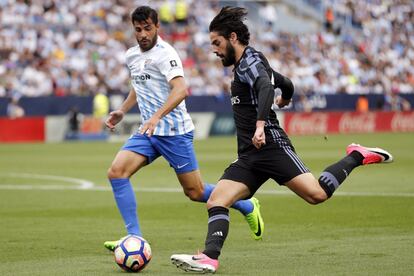 El centrocampista del Real Madrid Isco avanza ante el defensa del Málaga Luis Hernández.