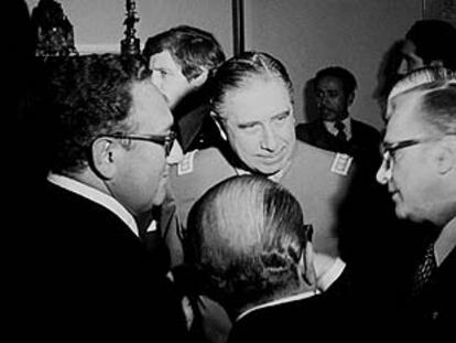 Henry Kissinger (izquierda) junto al general Augusto Pinochet charlan con dos hombres no identificados.