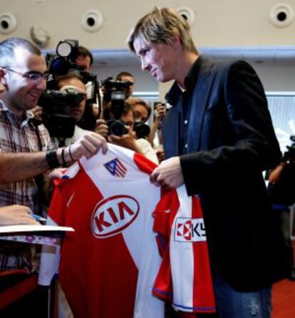 Fernando Torres firma una camiseta del Atlético, el día que oficializó su marcha al Liverpool en julio de 2007.