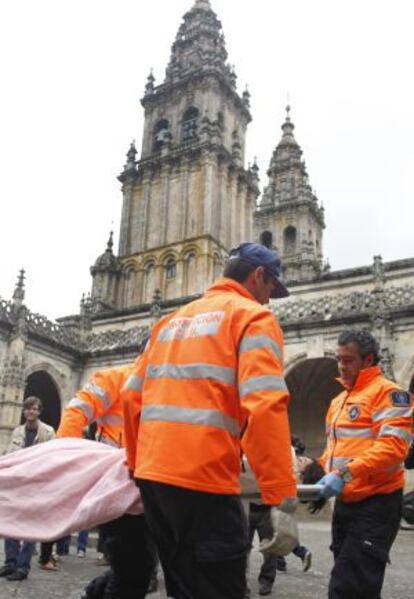 Una trabajadora del archivo es evacuada por Protecci&oacute;n Civil durante el simulacro en la Catedral.