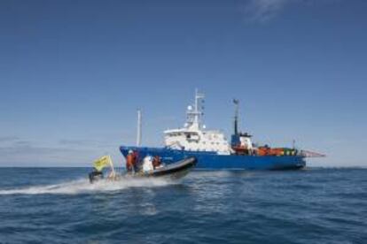 Fotografía facilitada por la organización ecologista Greenpeace con varios activistas a bordo de una lancha neumática del rompehielos Arctic Sunrise mientras se acerca al Akademic Lazarev (al fondo) un buque de investigación sísmica en el Mar de Bárents, en el norte de Rusia, mientras denuncia los preparativos de la petrolera rusa Rosneft para la perforación en busca de petróleo en el Ártico. EFE/Will Rose-Greenpeace