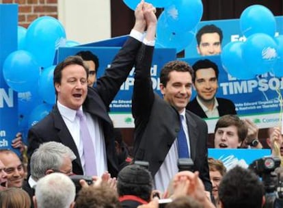David Cameron (izquierda) celebra la victoria con el nuevo miembro de los Comunes, Edward Timpson.
