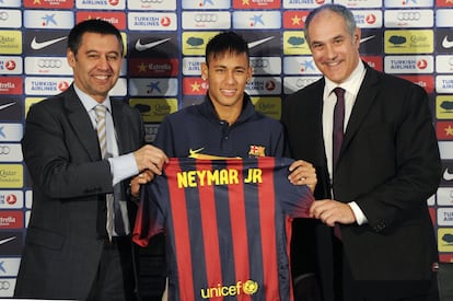 Neymar sostiene su nueva camiseta con el vicepresidente del FC Barcelona Josep Maria Bartolomeu (izquierda) y el director deportivo Andoni Zubizarreta durante su presentación oficial como nuevo jugador del Barcelona, el 3 de junio de 2013.