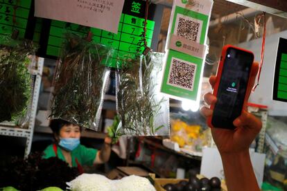 A person scans the QR code of the digital payment services WeChat Pay at a fresh market in Beijing, China August 8, 2020. REUTERS/Thomas Peter
