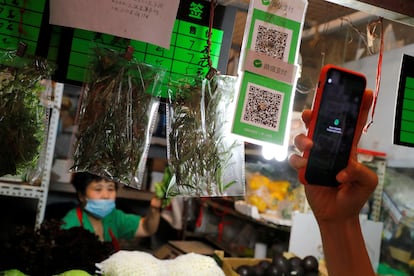 A person scans the QR code of the digital payment services WeChat Pay at a fresh market in Beijing, China August 8, 2020. REUTERS/Thomas Peter