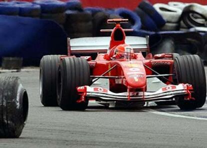 Una de las ruedas del accidentado Renault de Jarno Trulli corre delante del Ferrari de Michael Schumacher en Silverstone.