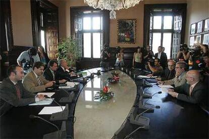 Los consejeros que elaboraron la propuesta de financiación del tripartito, con una delegación de CiU, en el Parlamento catalán.