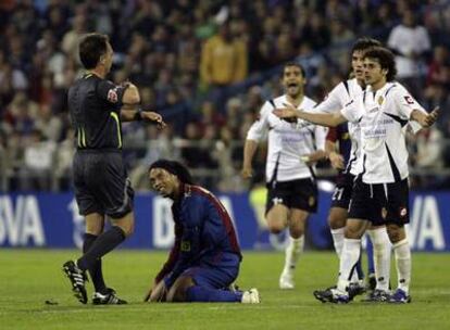 Ronaldinho, en el suelo, tras ser objeto de una falta en el partido ante el Zaragoza.