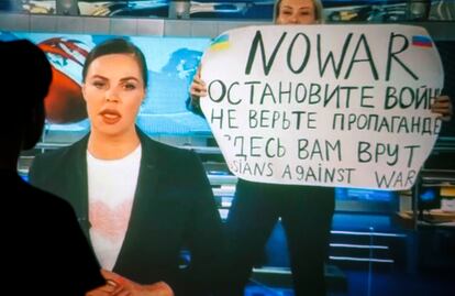 Una mujer ve la interrupción de la programación del primer canal de la televisión rusa por la editora de internacional, Marina Ovsianikova, con un cartel contra la guerra de Rusia contra Ucrania, este 15 de marzo.