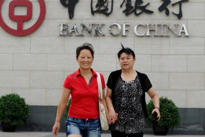 Dos mujeres pasean ante el Banco de China en Pekín.