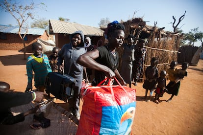 (En el centro) Keich Zaud, una mujer de Kordofán del Sur (Sudán) prepara sus pertenencias para viajar con sus hijos desde el campo de refugiados Ajuong Thok (Sudán del Sur) a Maban, en la parte occidental del país. Zaud, que tiene cuatro hijos, va a reunirse con su marido en Maban después de tres años separados a causa del conflicto en su lugar de origen. La reunión familiar entre refugiados que viven en Sudán del Sur está promovida y financiada por ACNUR.