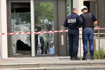 Agentes de la policía francesa junto a la entrada del Ayuntamiento de Mons-en-Barœul, cerca de Lille, dañada durante los disturbios, este jueves. 