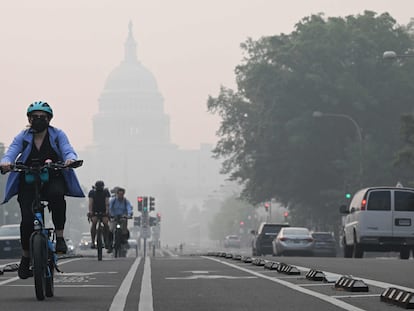 Ciclistas circulaban este jueves bajo una capa de neblina que oscurecía parcialmente el Capitolio de Washington.