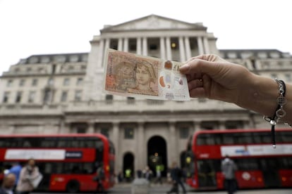 El nuevo billete frente al Banco de Inglaterra, en Londres, este jueves.