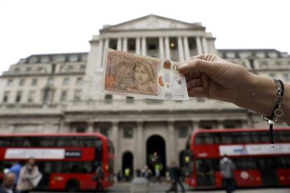 El nuevo billete frente al Banco de Inglaterra, en Londres, este jueves.