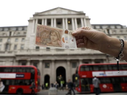 El nuevo billete frente al Banco de Inglaterra, en Londres, este jueves.