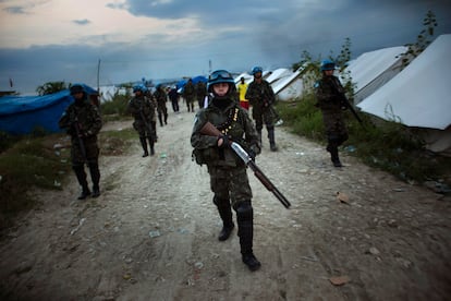 Cascos azules de la misión de paz de 2010 patrullan un campamento de refugiados tras el brote de cólera.